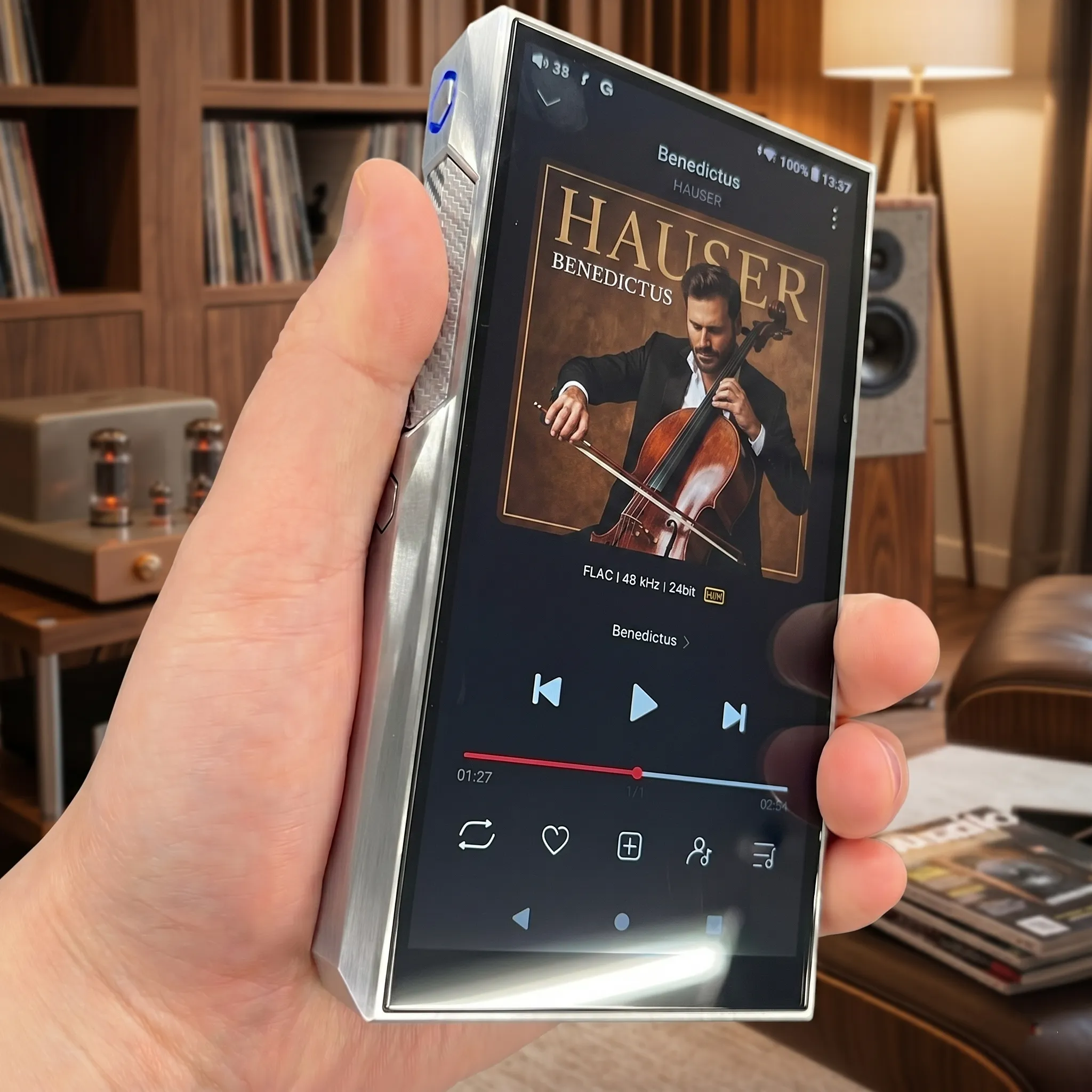 Плеер FiiO M23 в руке: экран с обложкой альбома, карбоновая вставка и подсветка.