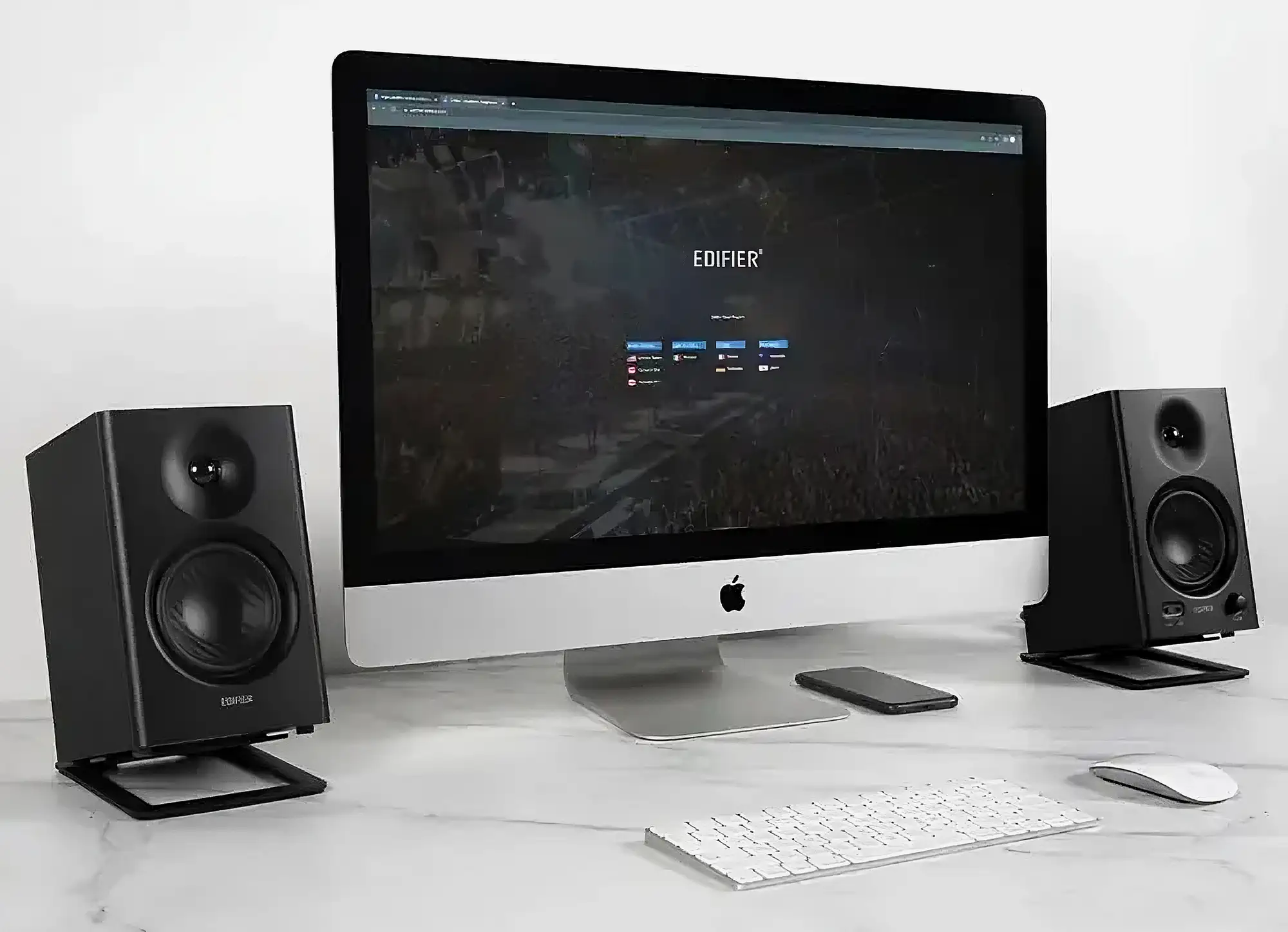 Колонки Edifier MR4 по бокам от iMac на подставках. Рабочее место с клавиатурой и мышью.