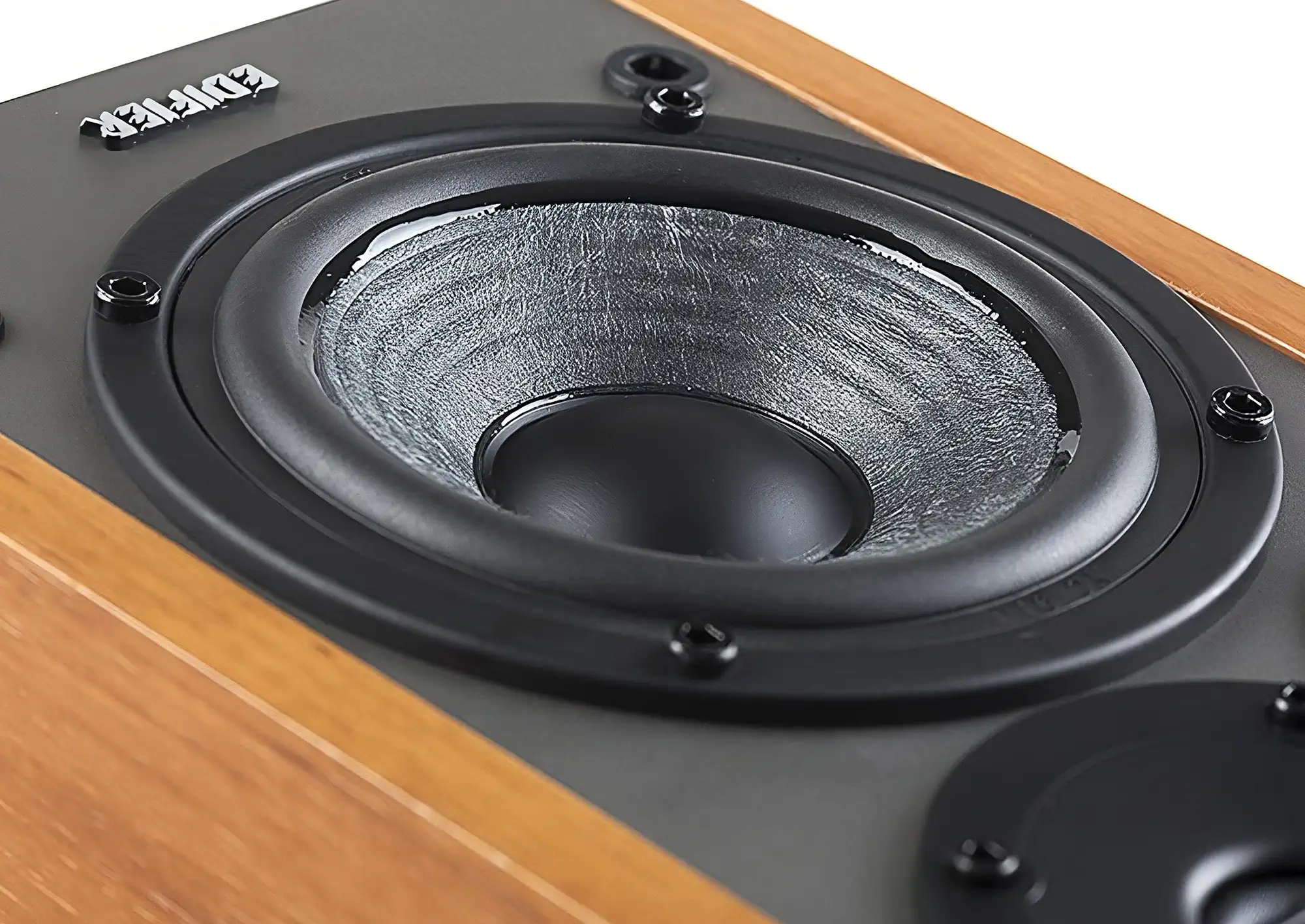 НЧ-динамик Edifier R1280DBs с серым диффузором, закрепленным винтами, крупным планом сбоку.