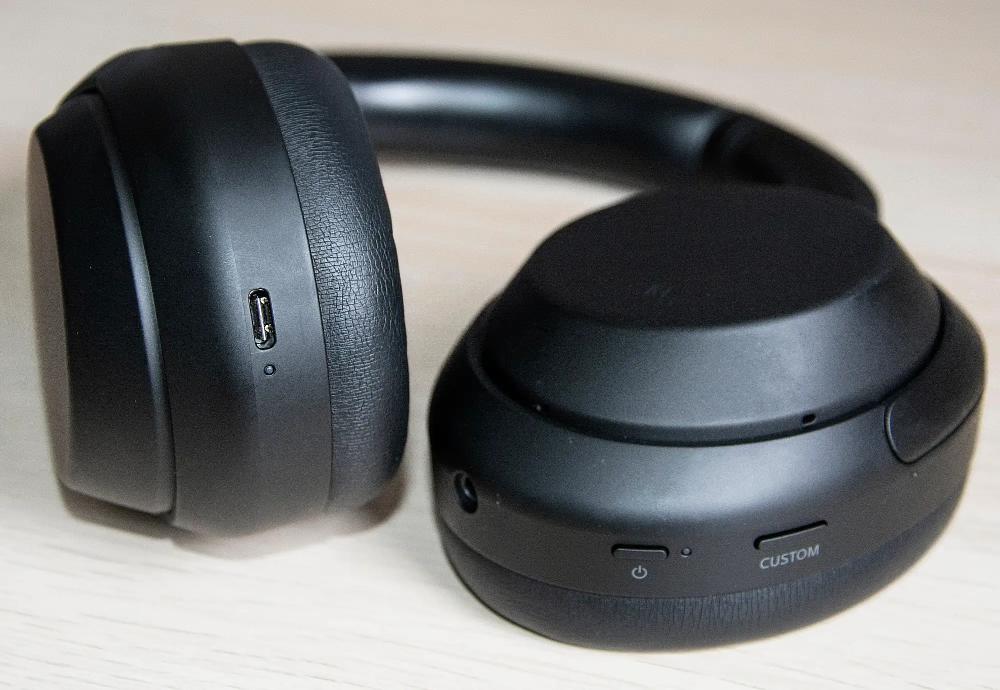 Sony WH-1000XM4: порт USB-C и кнопки Custom, питания и аудиовход на чашках, крупный план.