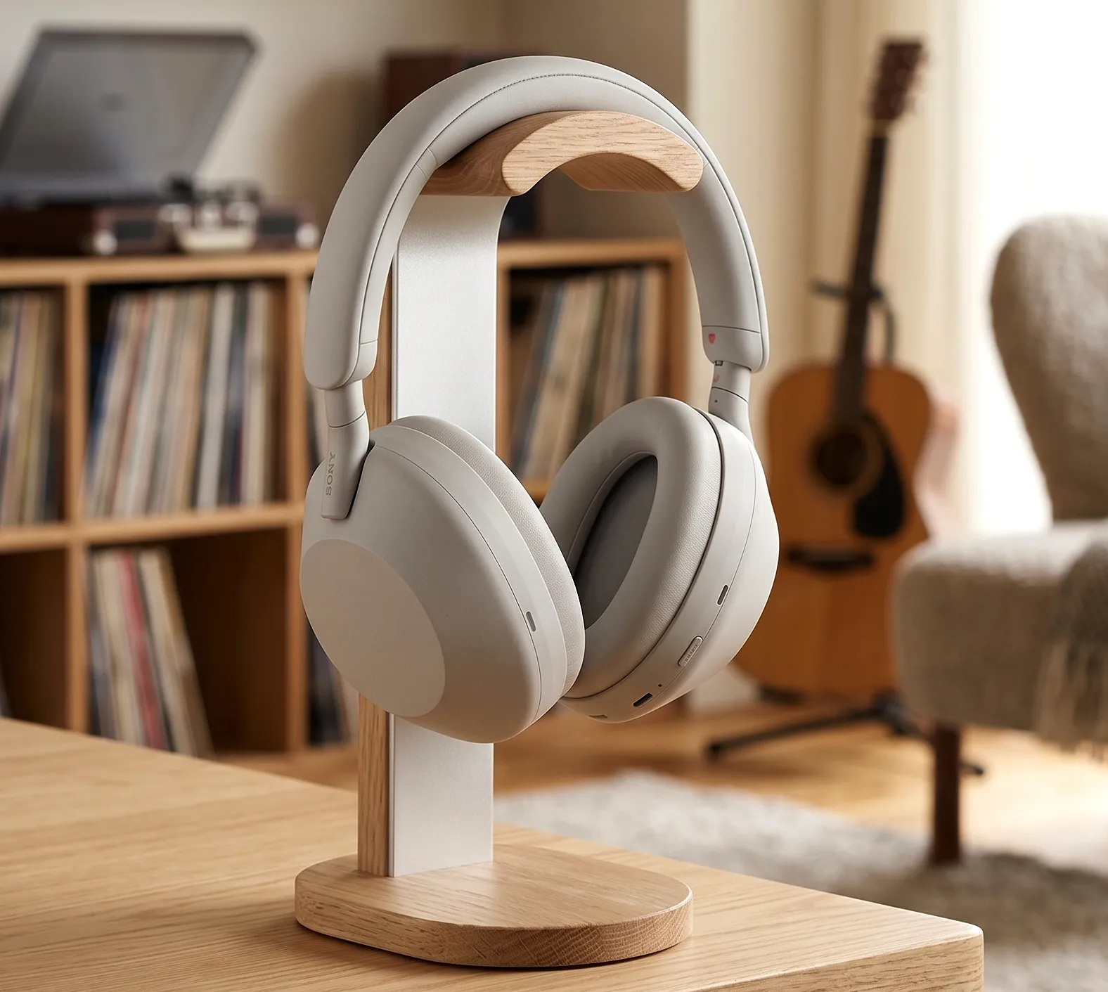 Sony WH-1000XM6 на комбинированной стойке: фон – гитара и стеллаж, мягкий свет с эффектом боке.