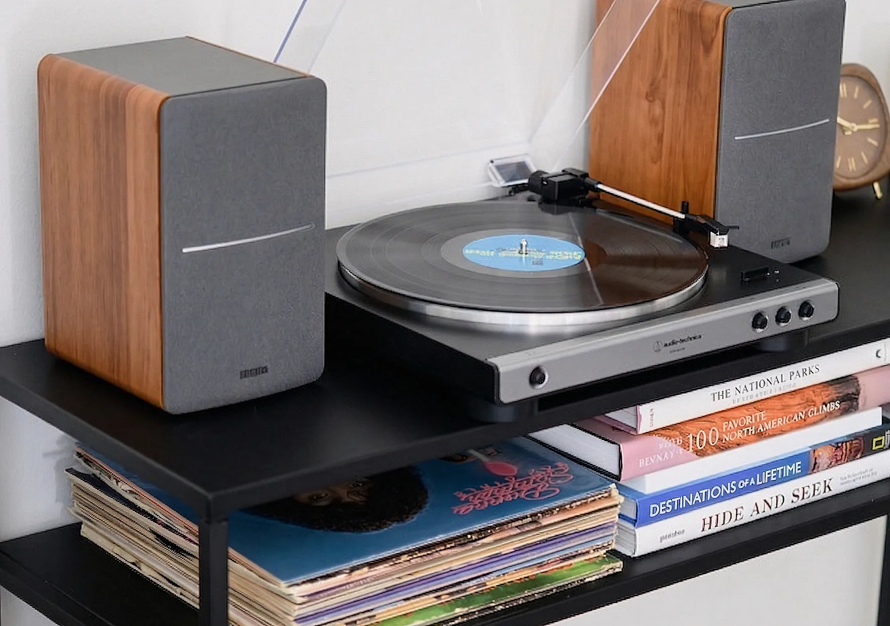 Проигрыватель Audio-Technica AT-LP60X и колонки Edifier R1280 на полке рядом с виниловой пластинкой.