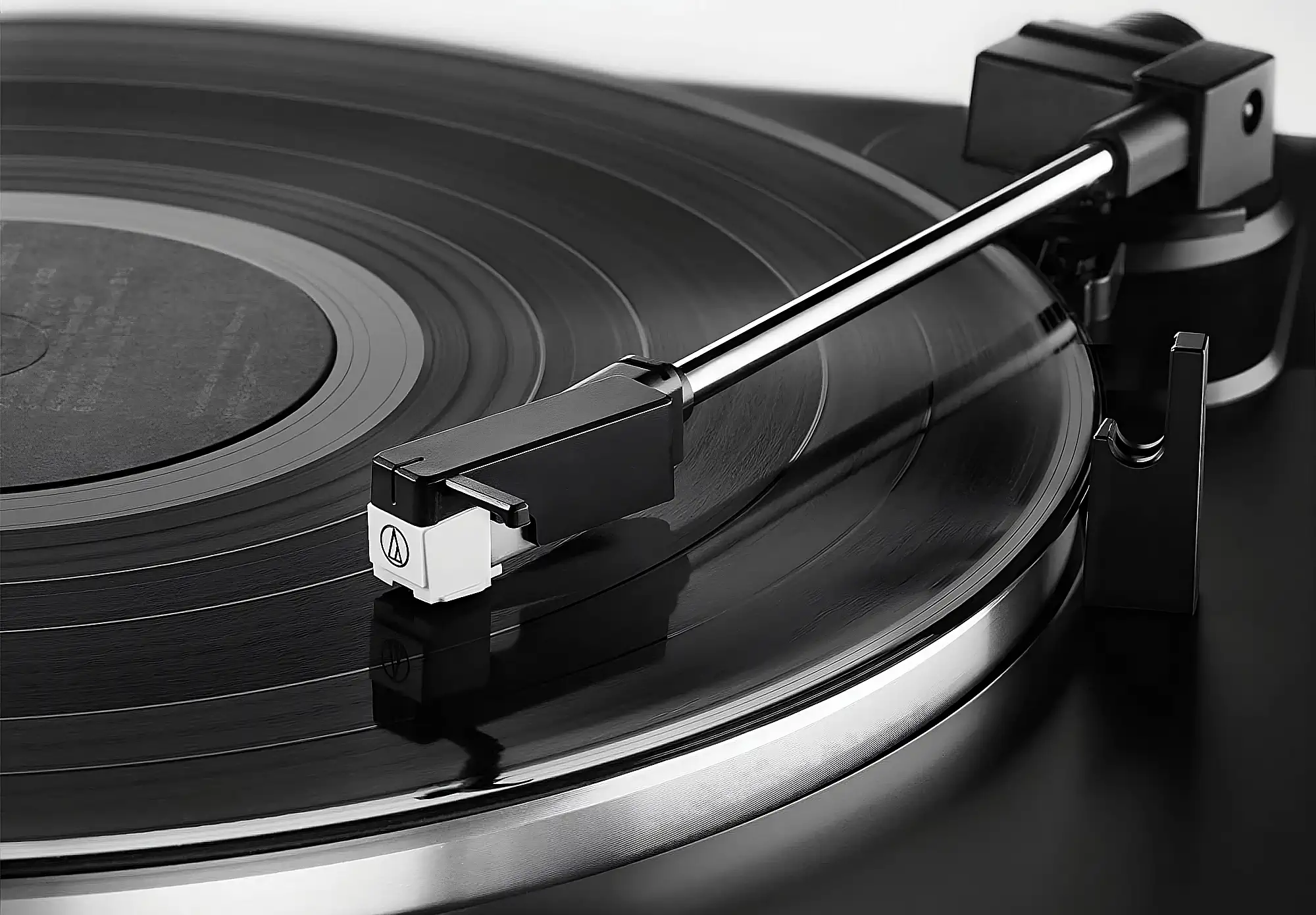 Звукосниматель AT3600L на тонарме Audio-Technica AT-LP60X со стилусом на пластинке.