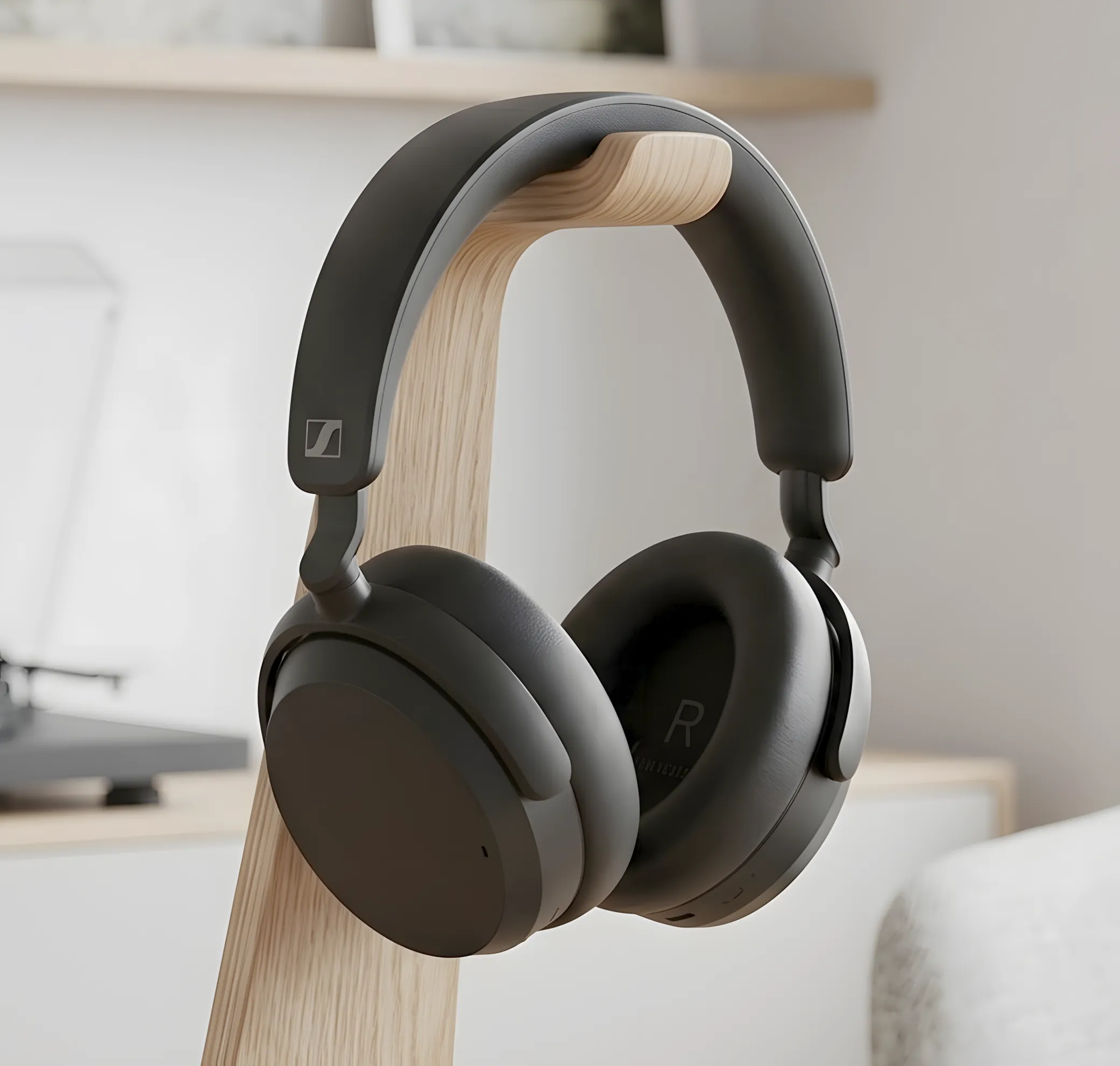 Sennheiser ACCENTUM Plus: черные наушники на деревянной стойке, вид в три четверти, фон – проигрыватель и пластинки.