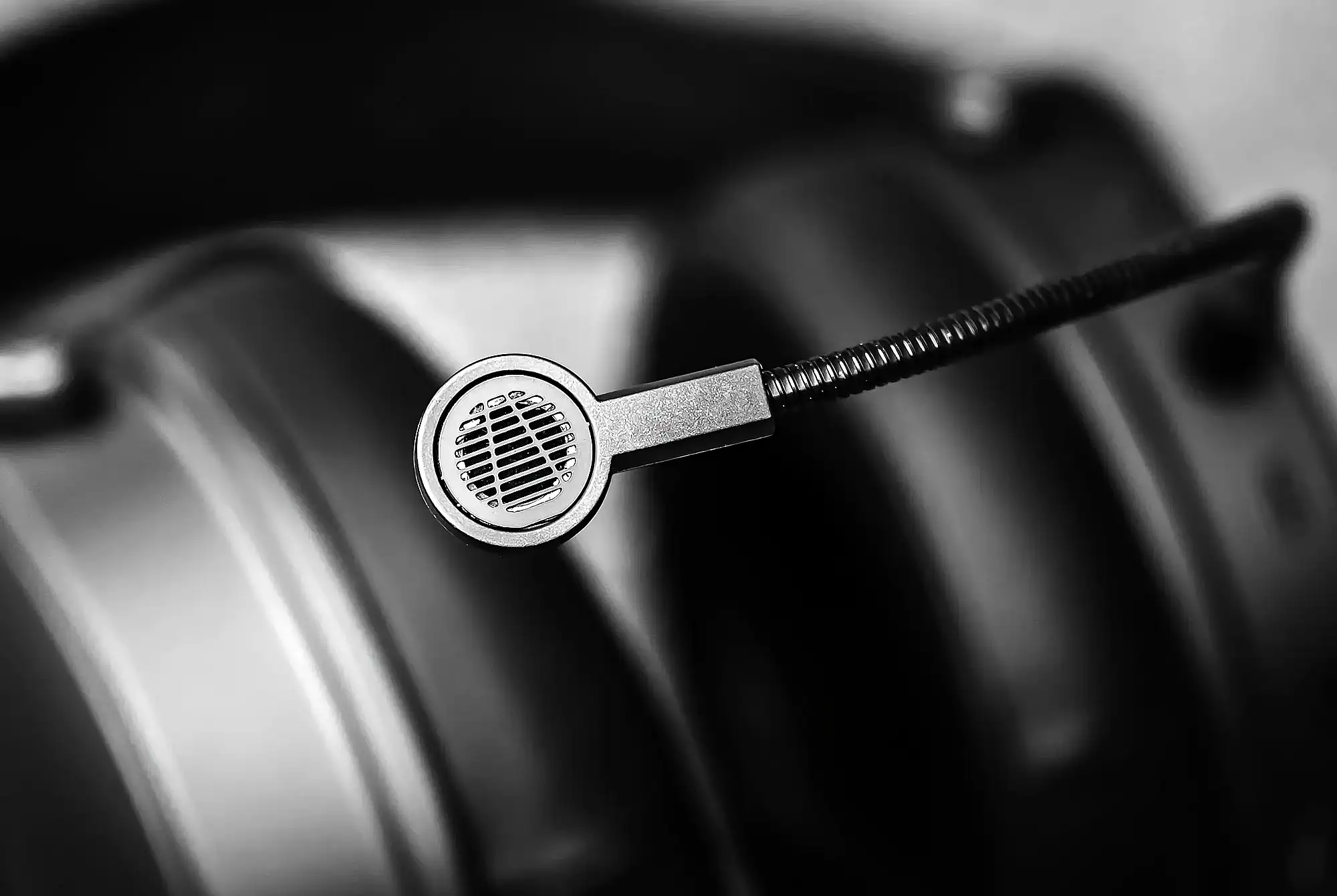 Audeze Maxwell: макро микрофона на гибкой штанге с металлической решеткой, наушники в расфокусе, черно-белое фото.