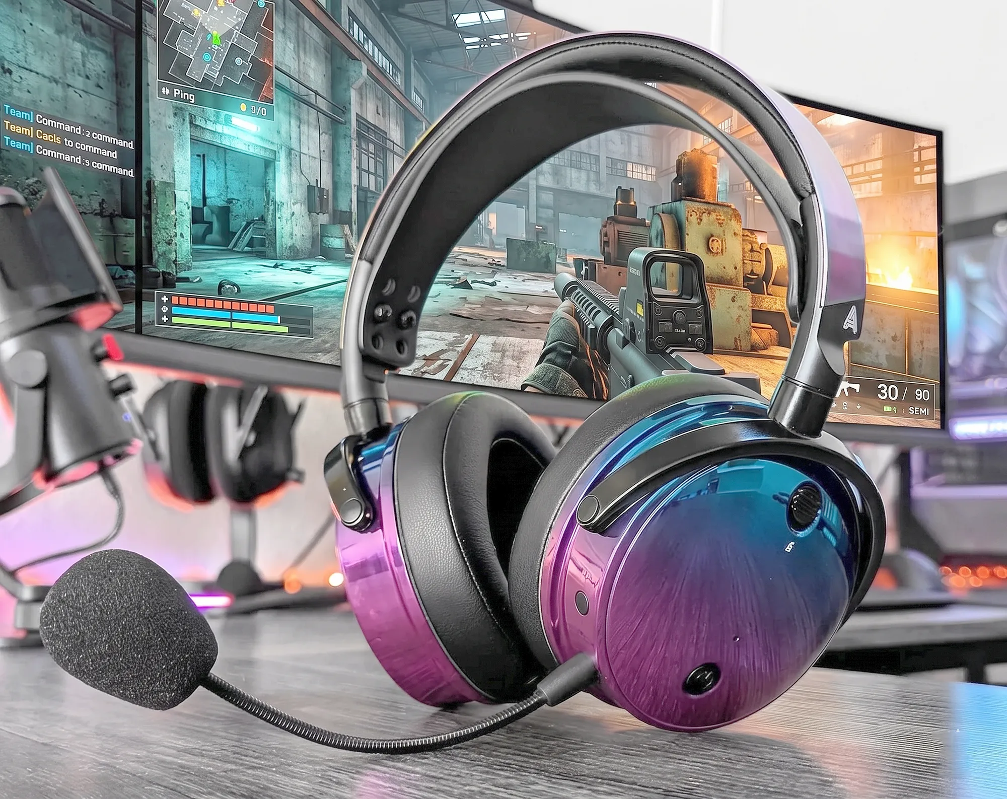 Audeze Maxwell версия Ultraviolet – наушники на деревянном столе, вид в три четверти. Металлические чашки с градиентом фиолетово-синего хамелеона, микрофон слева. Фон – монитор с игрой.