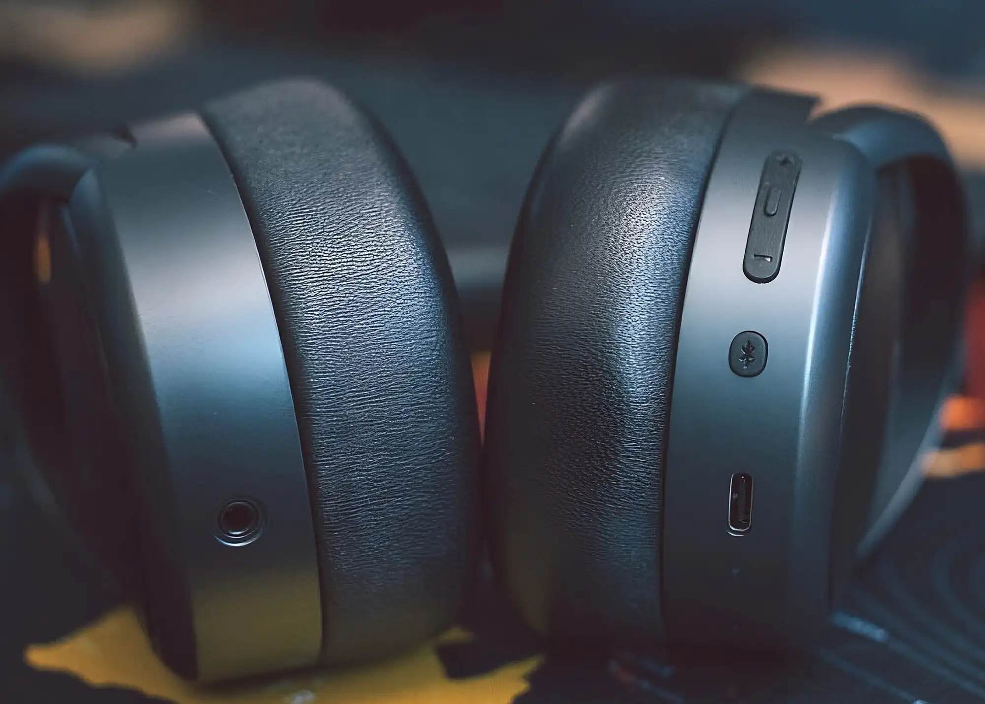 Edifier Stax Spirit S5: нижняя часть чашек, разъем 3,5 мм, кнопки и USB-C, текстура амбушюр, темный фон.