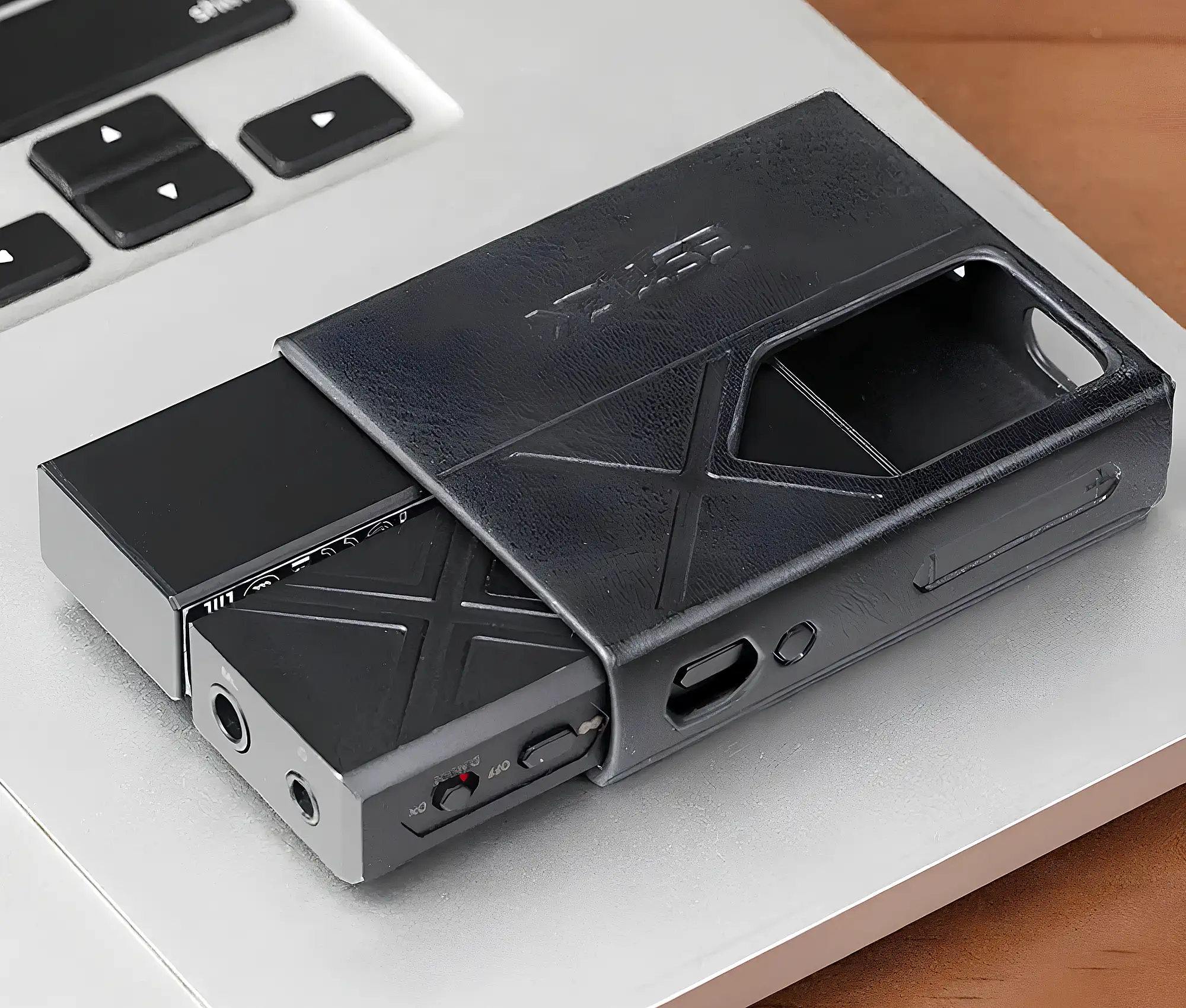 FiiO KA17 и ESTICK: устройства в черном кожаном чехле на ноутбуке, вид сверху.