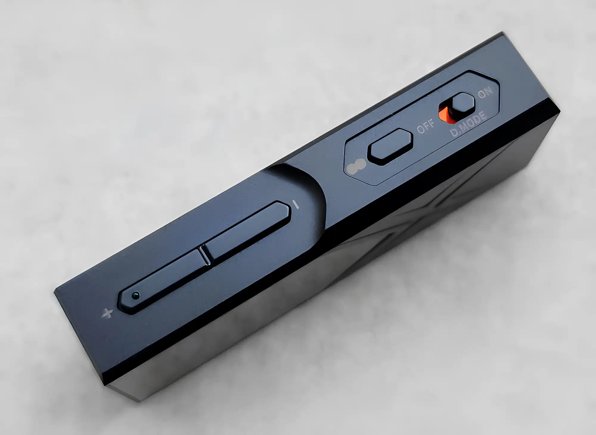 FiiO KA17: черный ЦАП, вид на боковую грань, качелька громкости, кнопка и тумблер с оранжевой меткой.