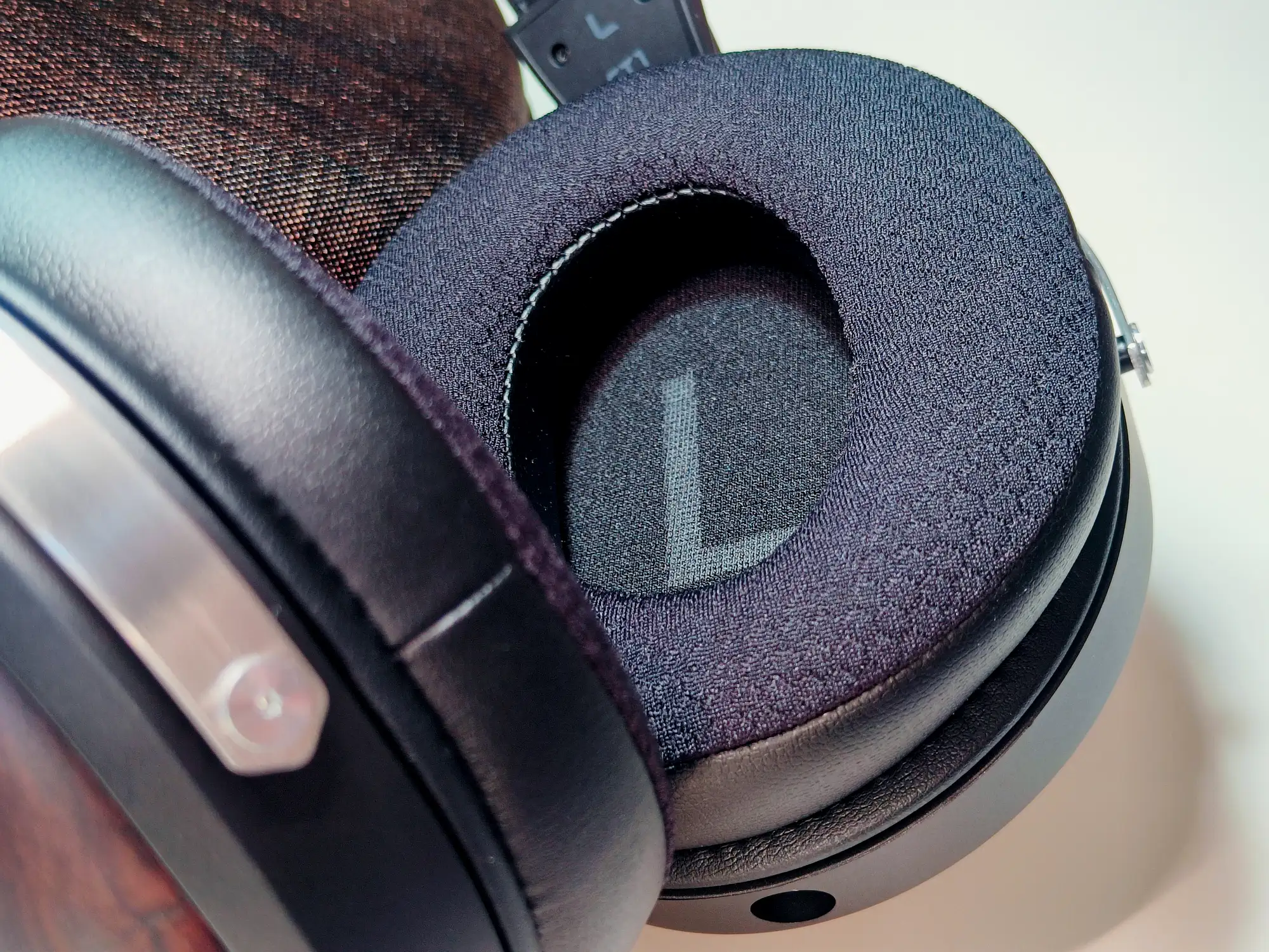 FiiO FT1: гибридные амбушюры, тканевая внутренняя часть с буквой L, крупный план на светлом фоне.