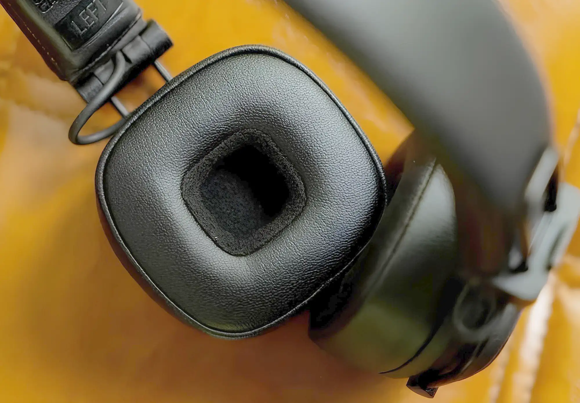 Marshall Major V: кожаный амбушюр, черная квадратная деталь крупным планом на желтом фоне.