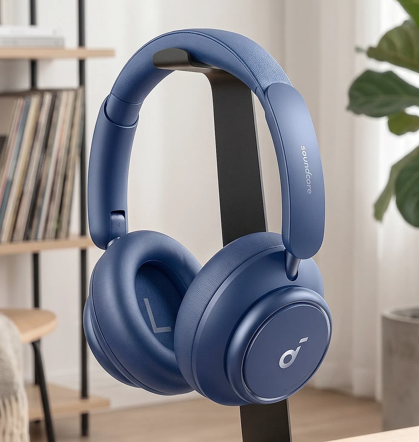 Anker Soundcore Space Q45: синие полноразмерные наушники на стойке, овальные чашки с логотипом, крупный план.