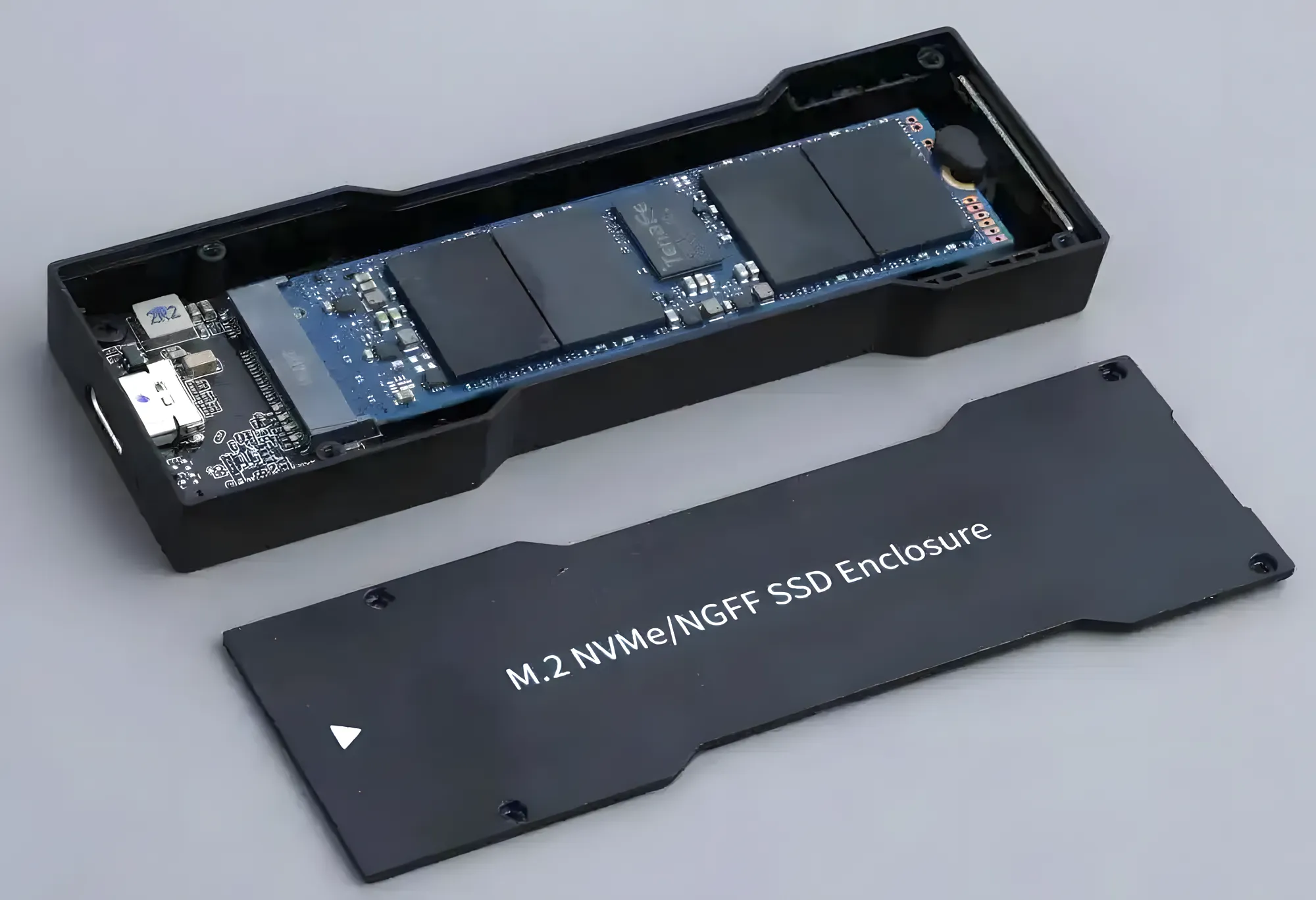 Разобранный блок для накопителя M.2 NVMe от FiiO S15. Вид сверху на плату с чипами в корпусе и снятую крышку.