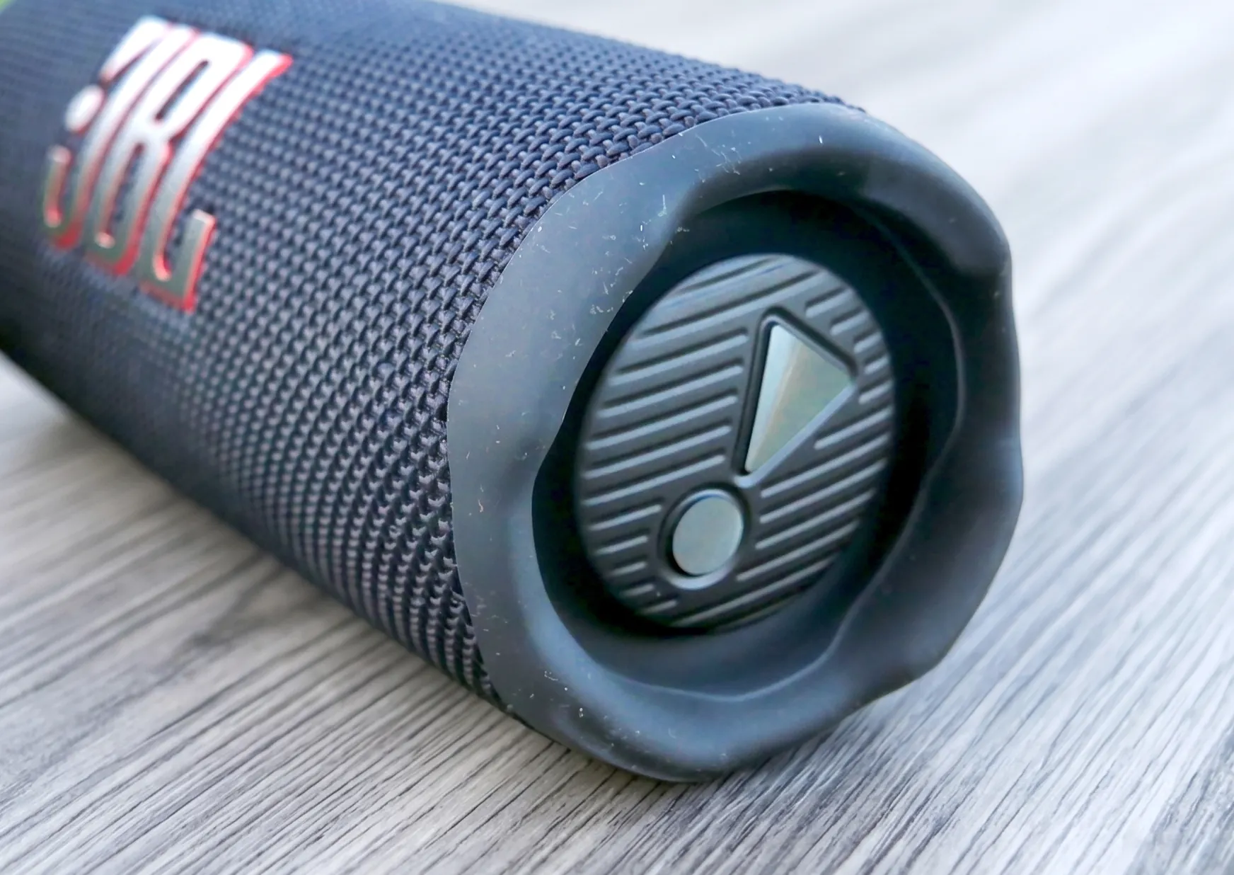 Пассивный излучатель на торце колонки JBL Flip 7. Макроплан бокового резинового бампера с логотипом.