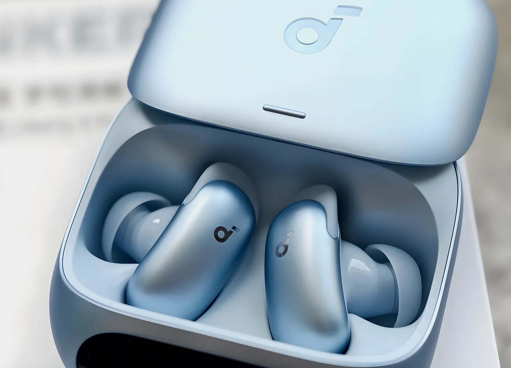 Наушники Soundcore Liberty 5 Pro в светло-синем зарядном кейсе. Крупный план открытого футляра со сдвинутой вверх крышкой.