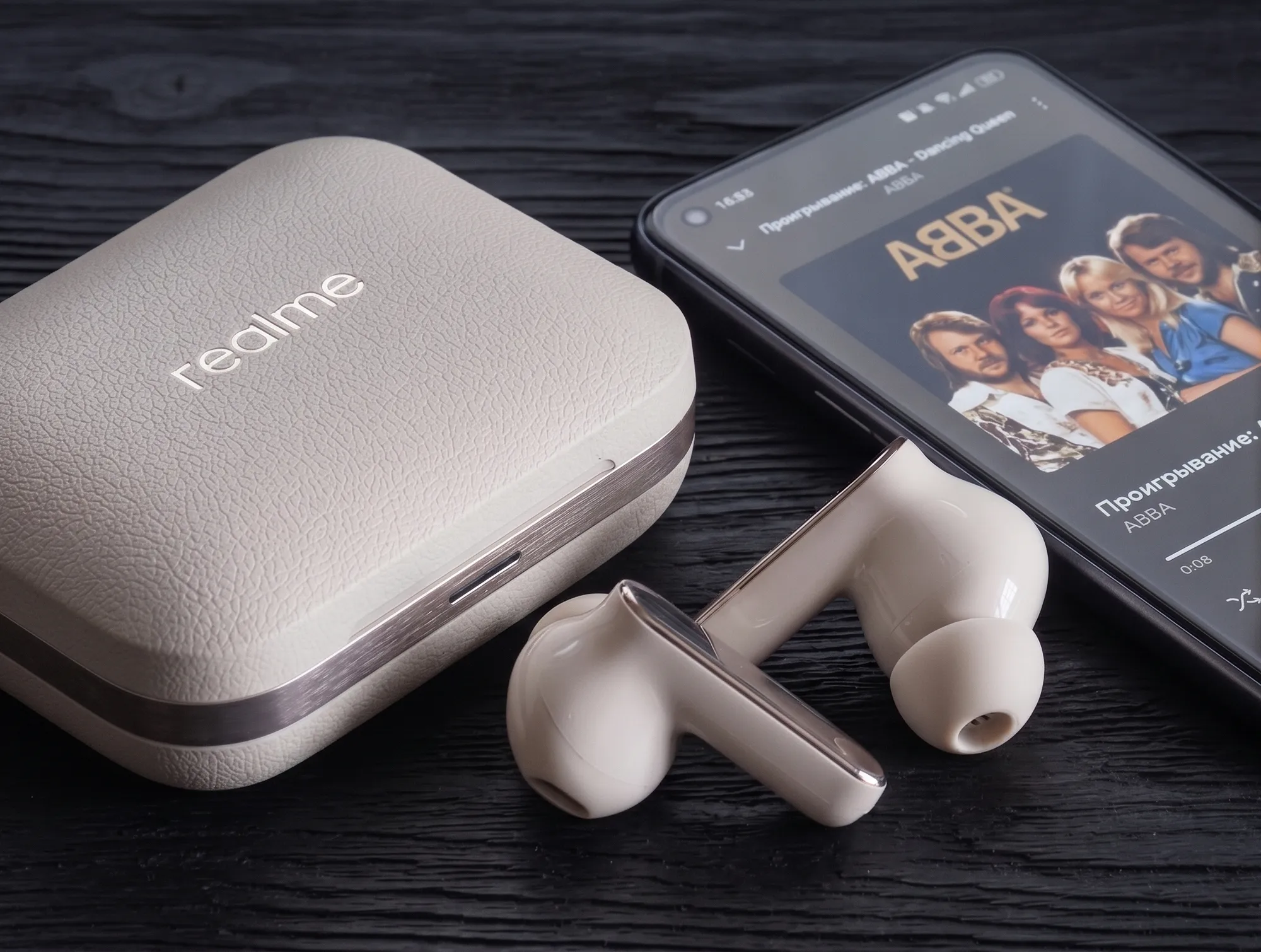 TWS–наушники Realme Buds Air 7 Pro рядом с кейсом и смартфоном.