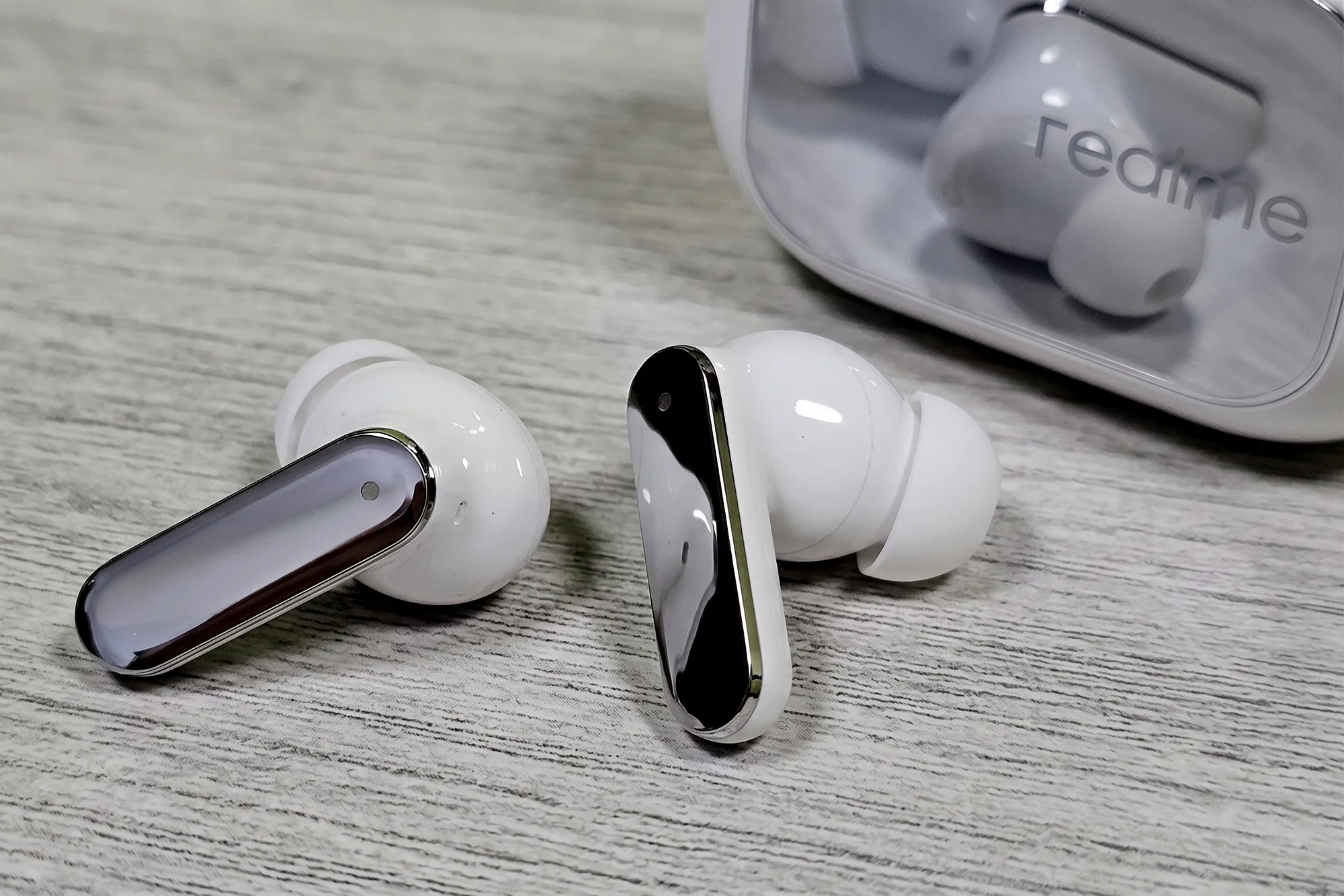 TWS–наушники Realme Buds Air 8 Pro белого цвета на фоне зарядного кейса.