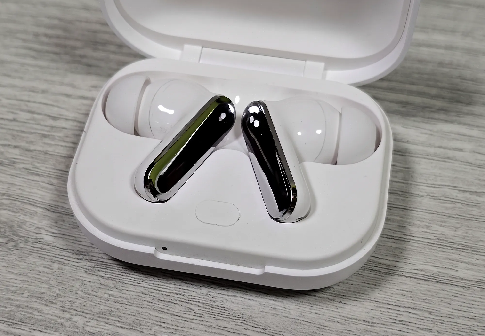 TWS–наушники Realme Buds Air 8 Pro в открытом белом зарядном кейсе.