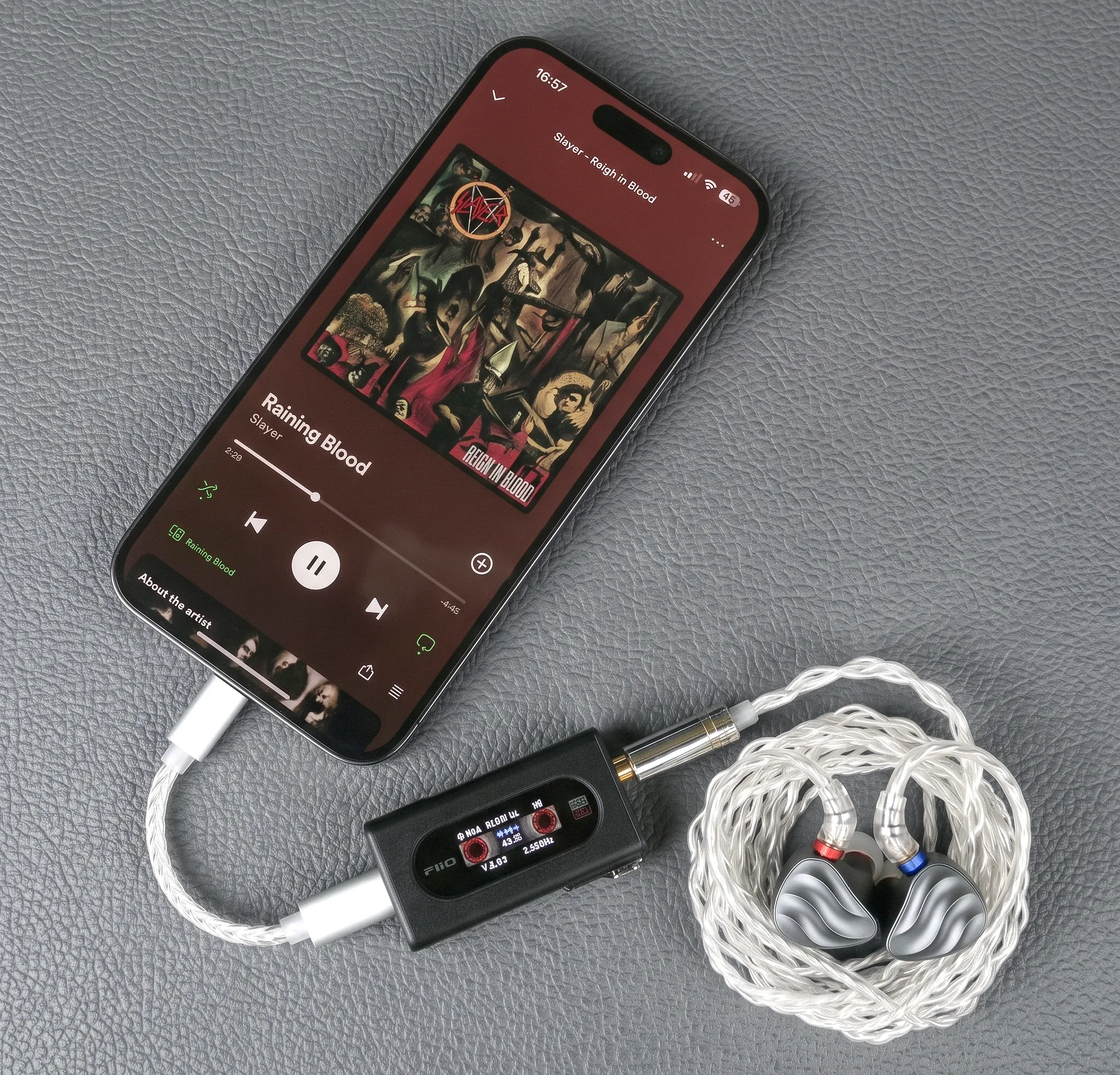 Портативный ЦАП-усилитель FiiO KA15 в связке со смартфоном и внутриканальными наушниками FiiO FH3 со скрученным серебристым кабелем.
