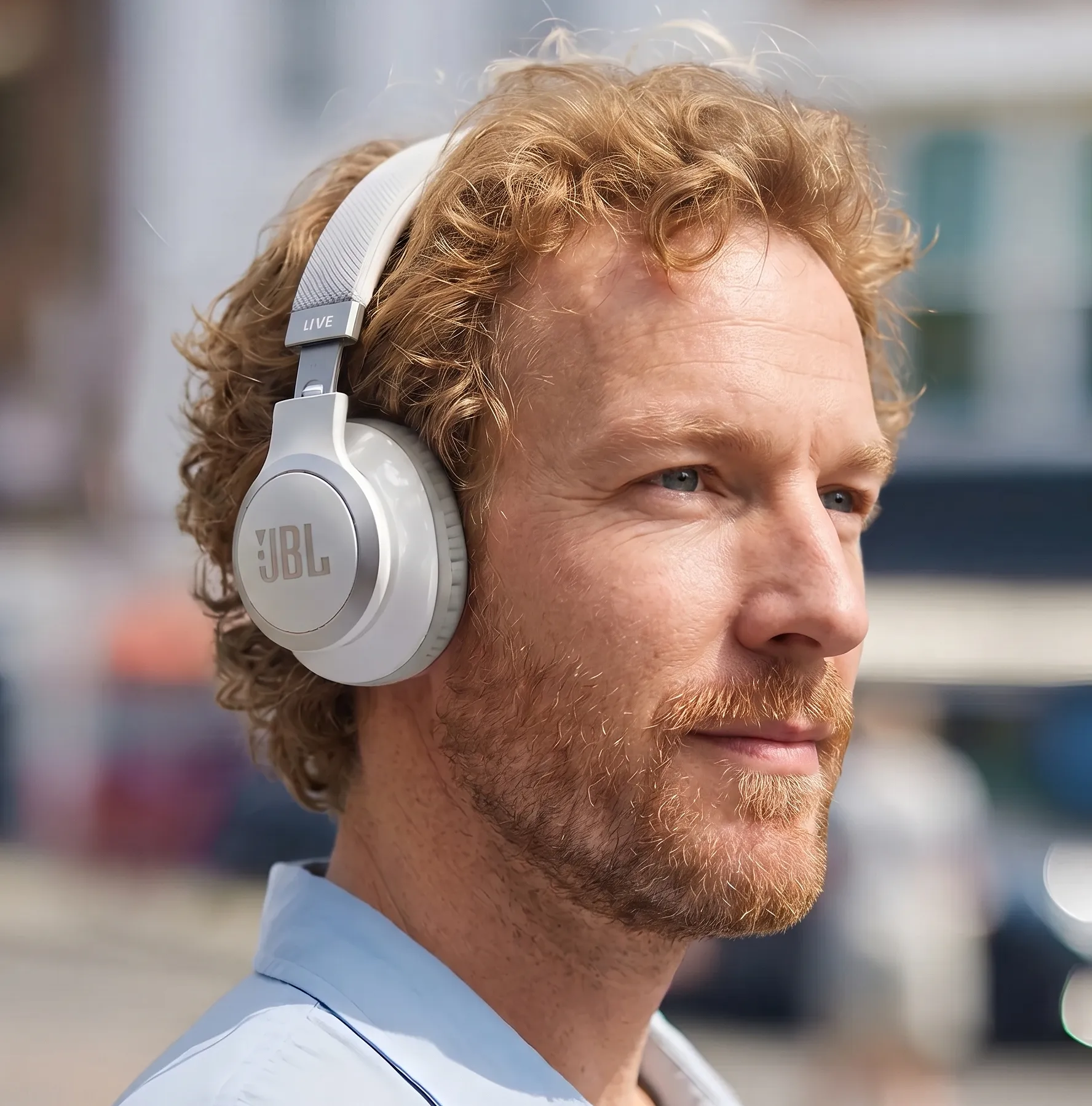 Автор обзора Павел Окопень в наушниках JBL Live 770NC белого цвета. 