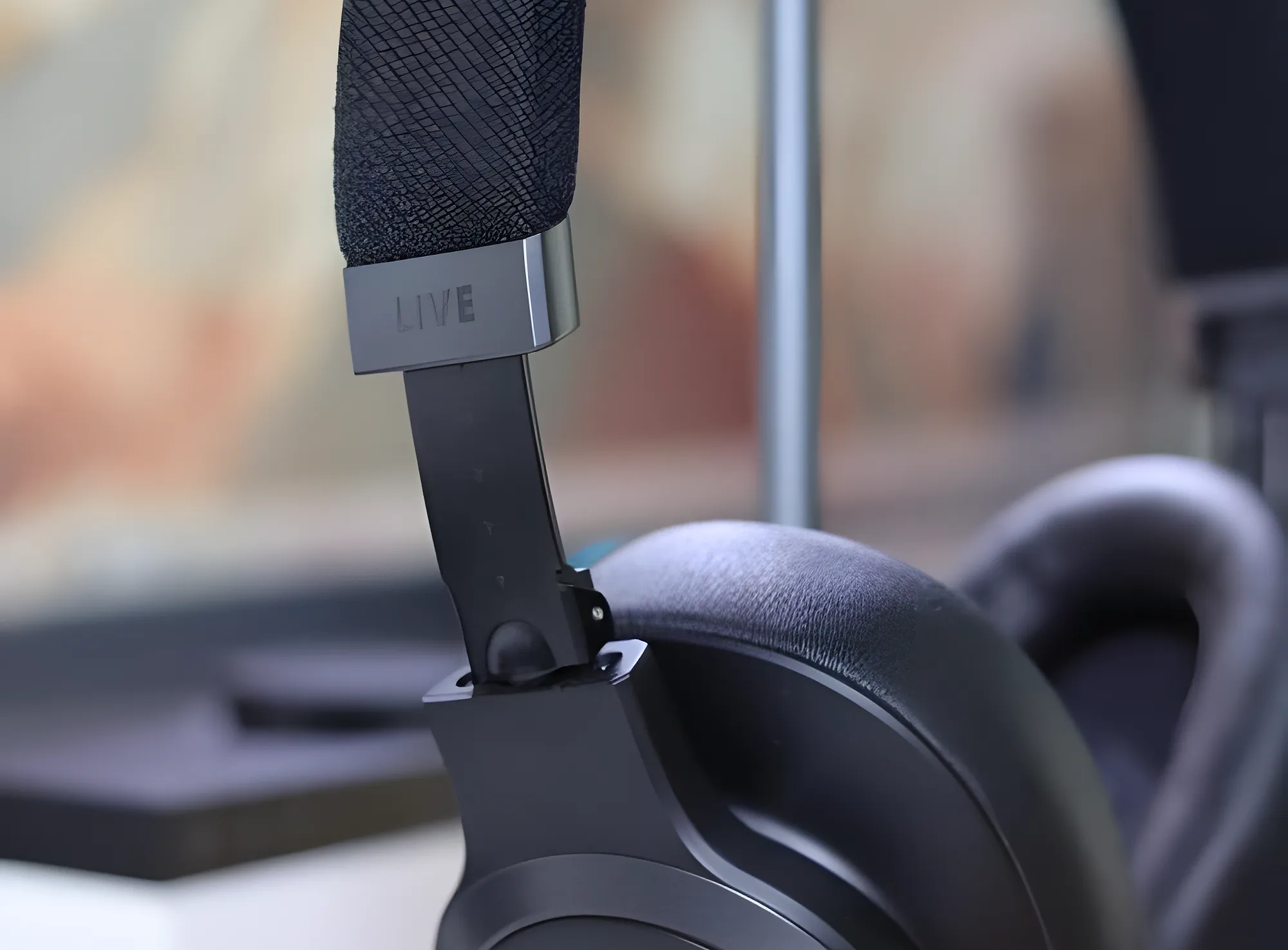 Оголовье JBL Live 770NC: выдвижная металлическая дужка с надписью LIVE крупным планом.
