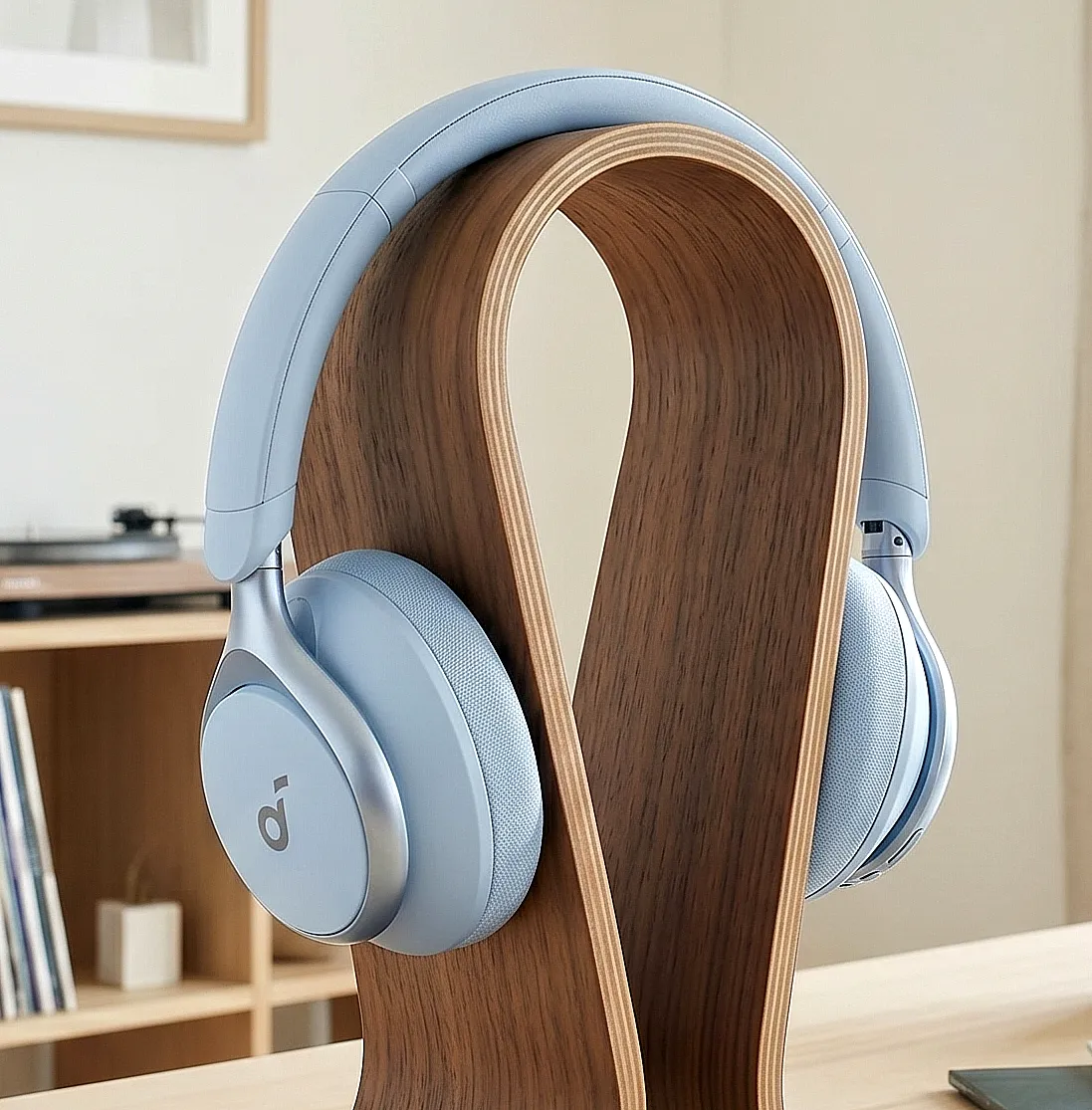 Наушники Anker Soundcore Space One голубого цвета на подставке с овальными чашками и логотипом.