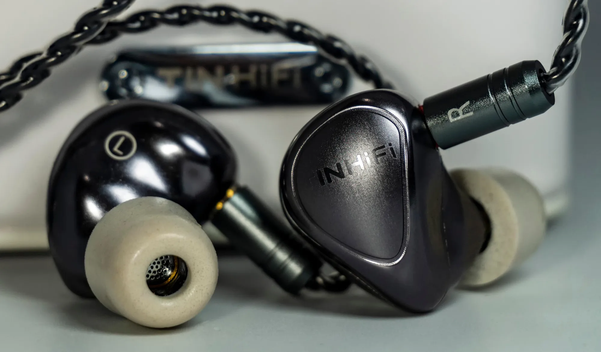 Наушники Tin HiFi T5: корпуса с логотипом, витой кабель и светлая амбушюра крупным планом.