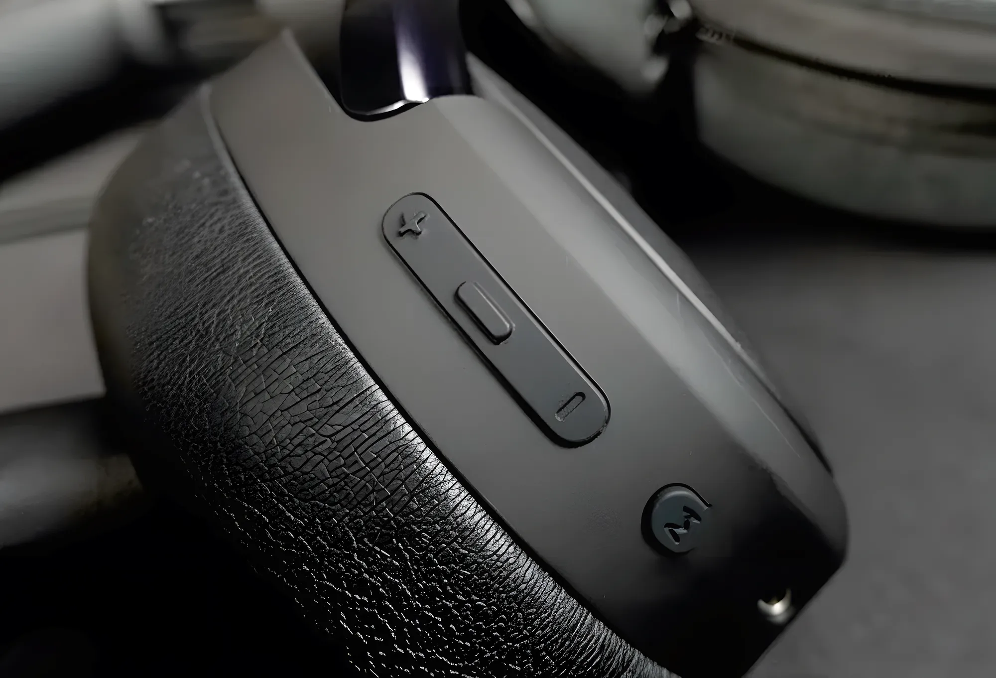 Крупный план чашки наушников Edifier WH950NB: видна фактура амбушюра, сверху блок кнопок громкости и переключения режимов на матовом корпусе.