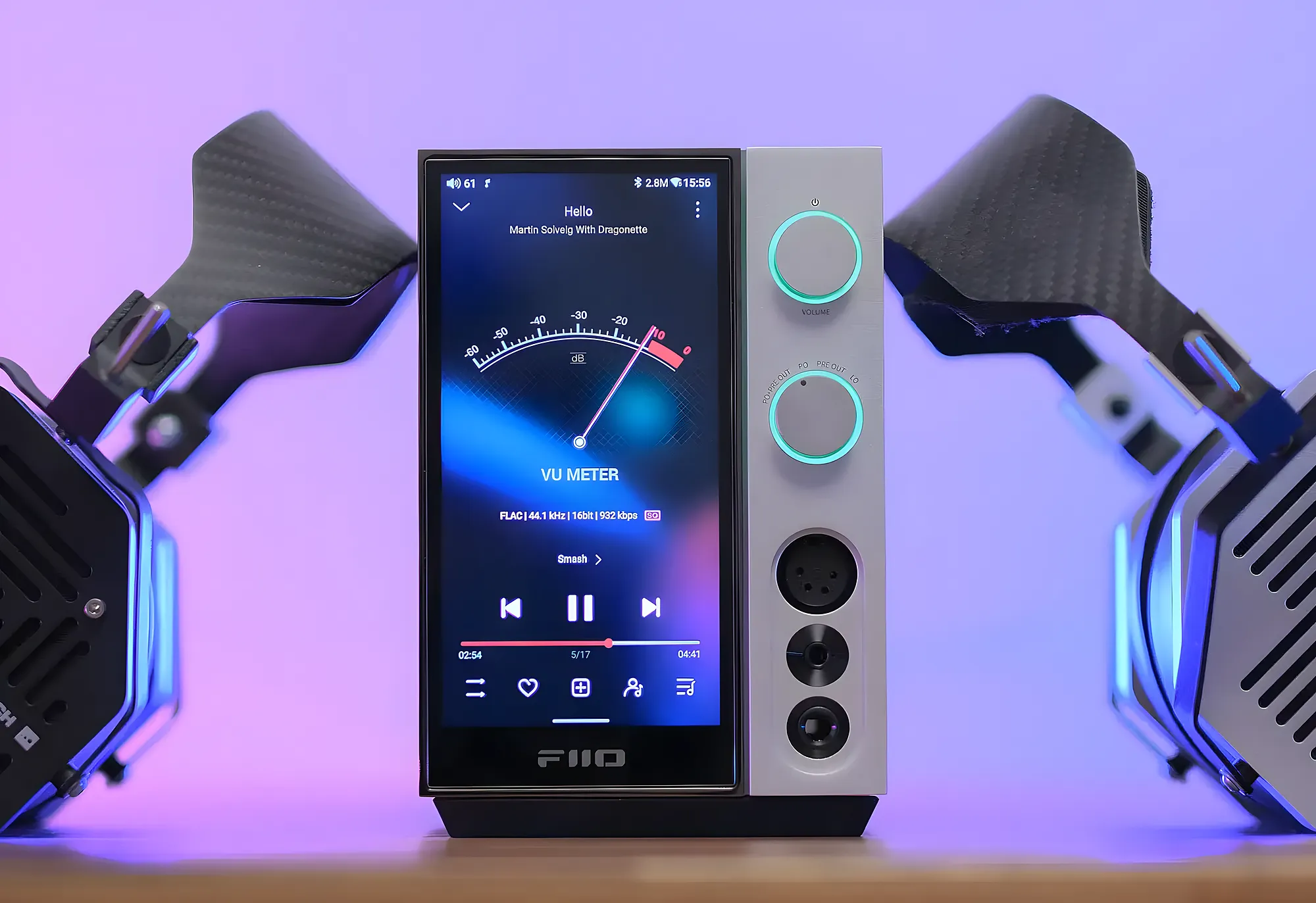 Стример FiiO R9. В центре – экран с VU-метром, справа – регуляторы с подсветкой. По бокам наушники Erzetich. Фронтальный вид на неоновом фоне.